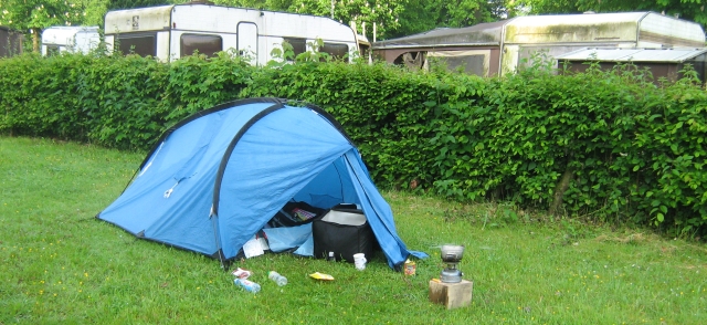 my small tent on a strip of grass with 2 dirty mouldy caravans in the background at the campsite in lebach